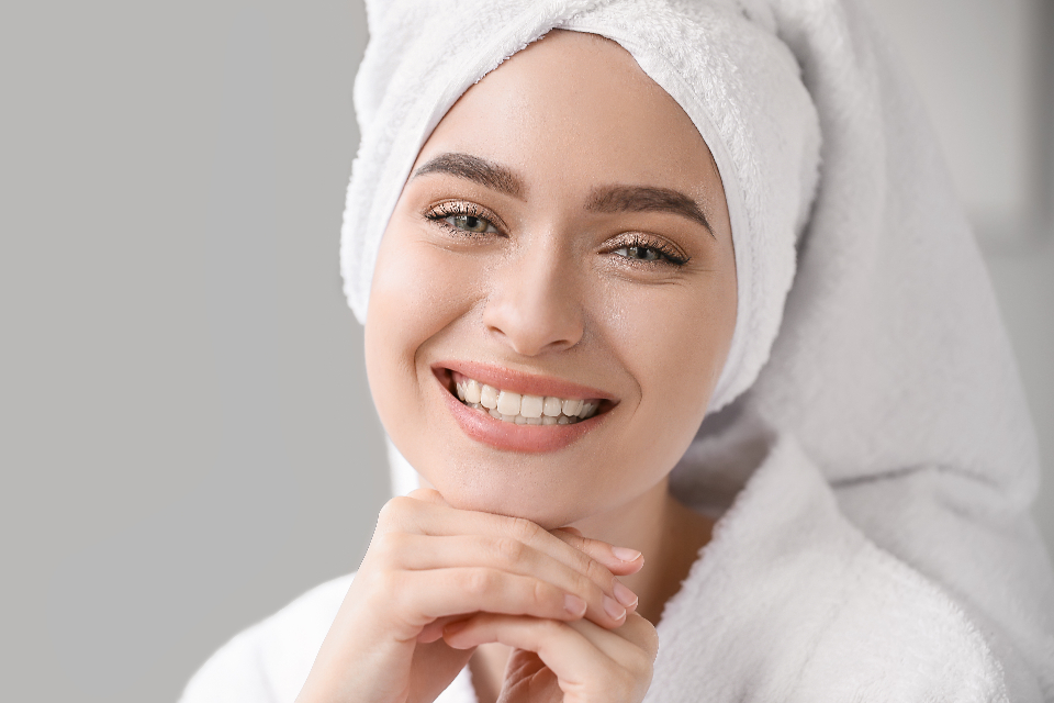 Mujer sonriendo, con una toalla en el pelo